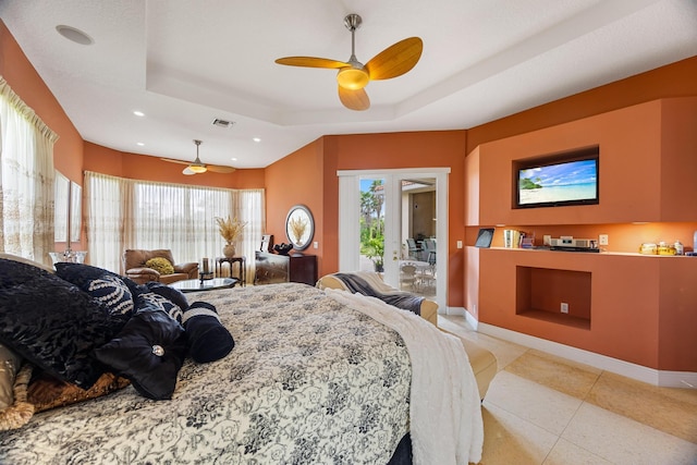 bedroom featuring ceiling fan, a raised ceiling, and multiple windows