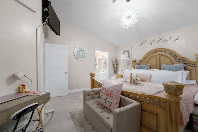 bedroom featuring ensuite bathroom, light hardwood / wood-style floors, vaulted ceiling, and an inviting chandelier