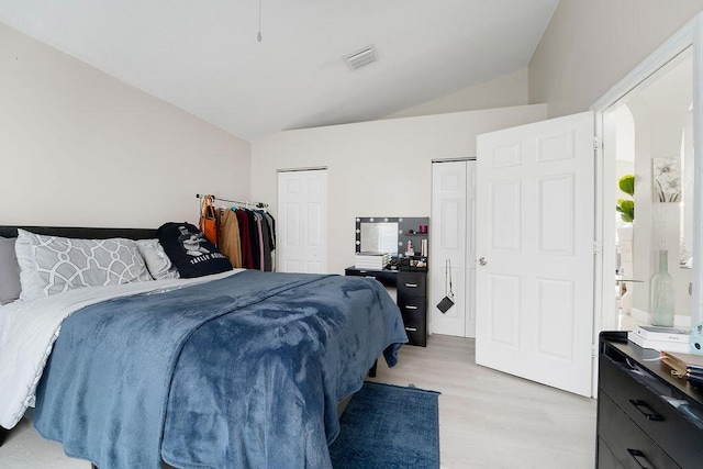 bedroom featuring light hardwood / wood-style flooring and lofted ceiling