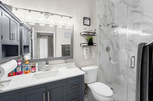 bathroom featuring vanity, toilet, and an enclosed shower