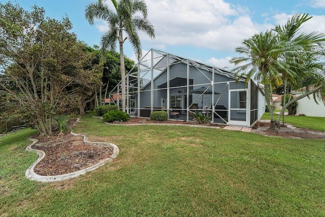 back of house featuring a lanai and a yard