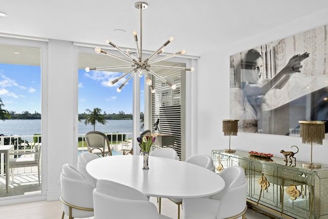 dining room featuring an inviting chandelier, plenty of natural light, light hardwood / wood-style flooring, and a water view