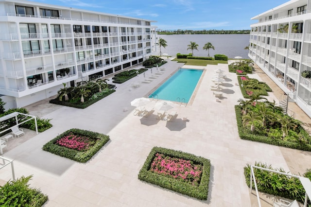 pool featuring a patio and a water view