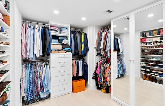 walk in closet with light hardwood / wood-style floors