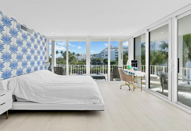 unfurnished bedroom featuring expansive windows, multiple windows, and wood-type flooring