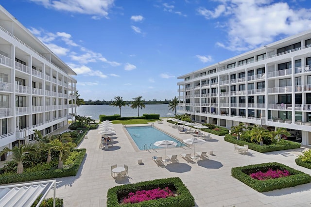 view of swimming pool featuring a water view and a patio