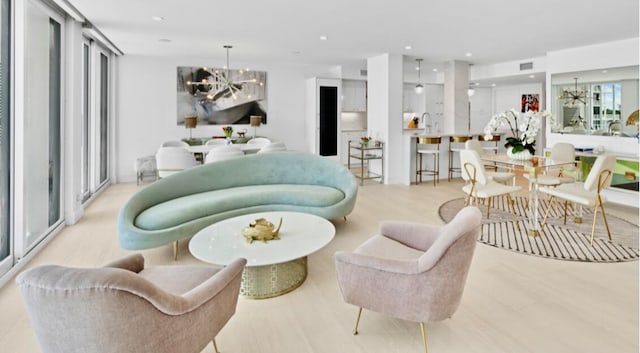 living room featuring light wood-type flooring and an inviting chandelier