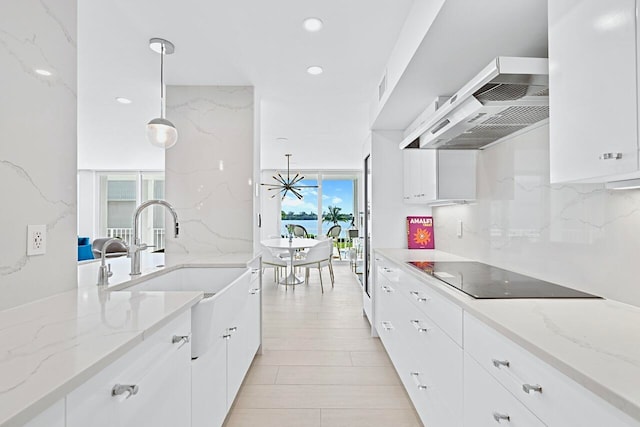 kitchen with a wealth of natural light, pendant lighting, and white cabinets