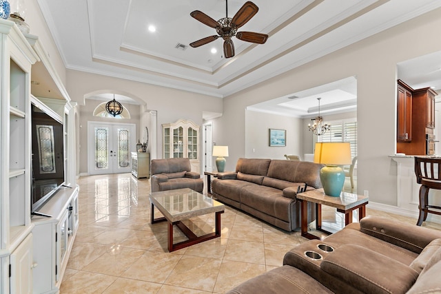 tiled living room with a wealth of natural light, a tray ceiling, and french doors