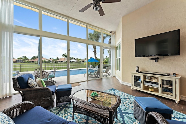 living room featuring ceiling fan, a textured ceiling, dark hardwood / wood-style floors, and a wealth of natural light