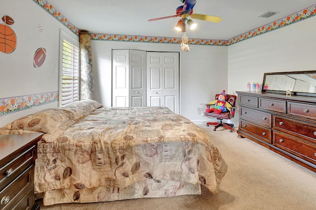 carpeted bedroom featuring a closet and ceiling fan