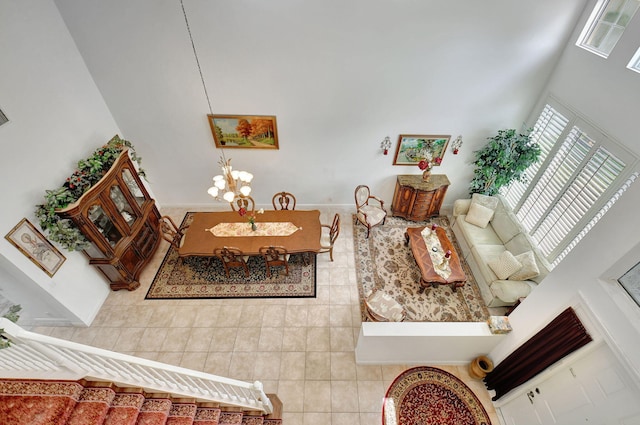 tiled living room with an inviting chandelier and a high ceiling