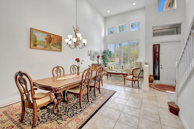 dining area featuring an inviting chandelier, a high ceiling, and light tile patterned flooring