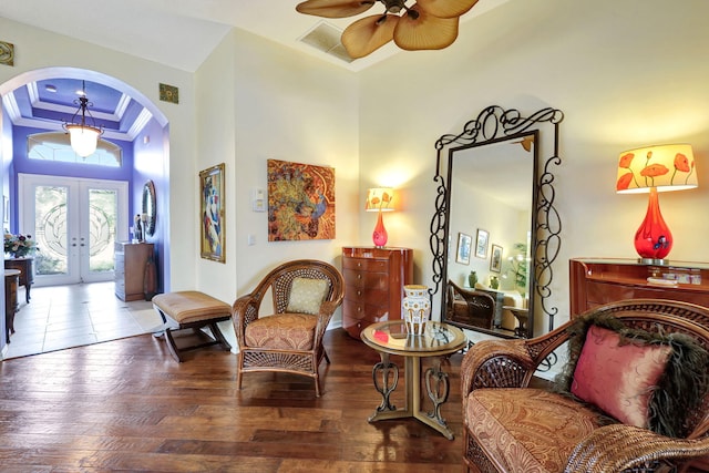 sitting room with a high ceiling, crown molding, ceiling fan, french doors, and hardwood / wood-style flooring