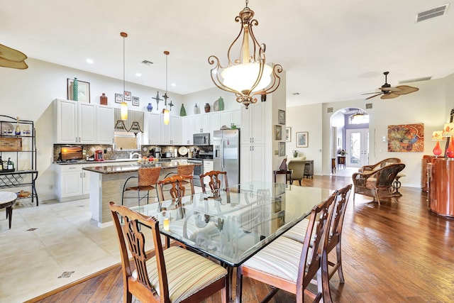 dining area with ceiling fan, sink, and light wood-type flooring