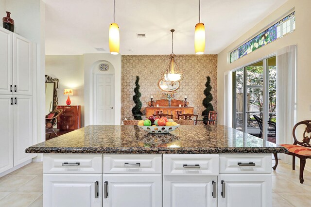 kitchen with white cabinetry, a center island, and dark stone counters