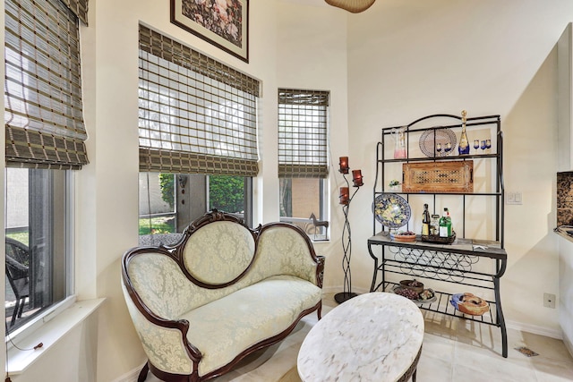 sitting room featuring light tile patterned floors and a high ceiling