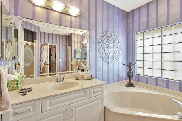 bathroom with a tub to relax in and vanity