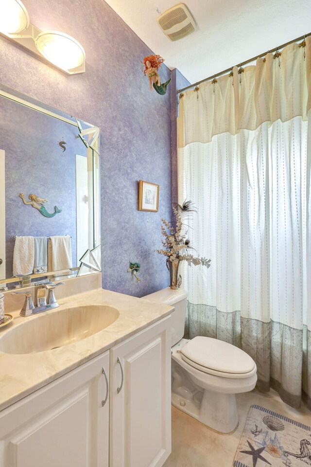 bathroom featuring vanity, toilet, and tile patterned flooring