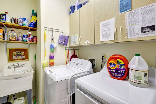 laundry area with washer and dryer, cabinets, and sink