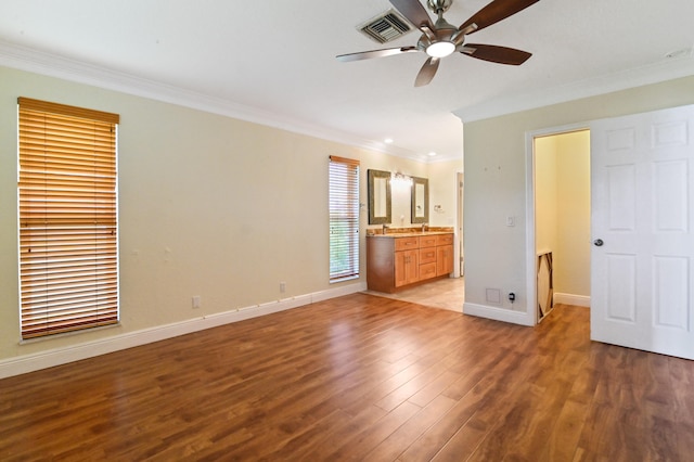 unfurnished bedroom featuring ensuite bathroom, ornamental molding, hardwood / wood-style flooring, and ceiling fan