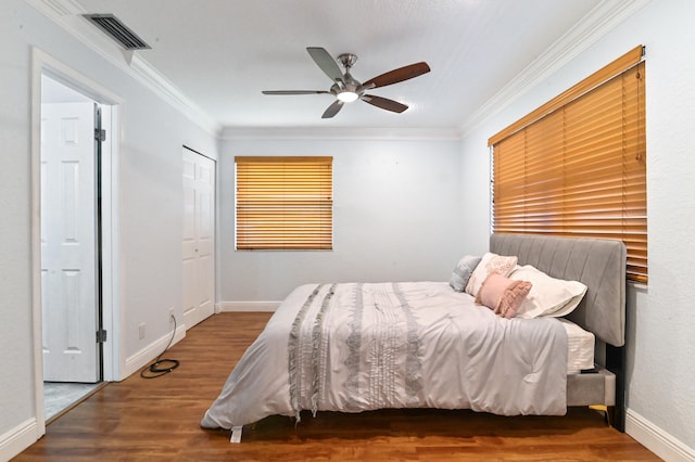 bedroom featuring ornamental molding, wood-type flooring, a closet, and ceiling fan