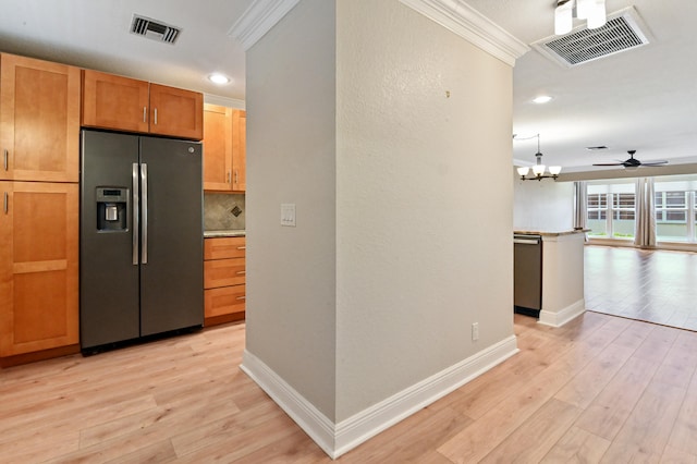 kitchen featuring light wood-type flooring, ceiling fan with notable chandelier, stainless steel appliances, decorative light fixtures, and ornamental molding