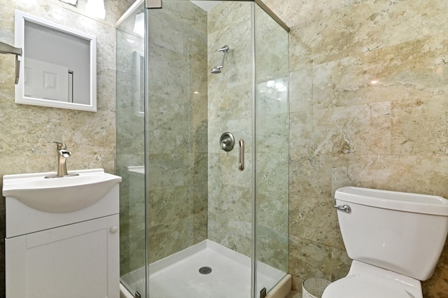 bathroom with toilet, walk in shower, vanity, and tile walls