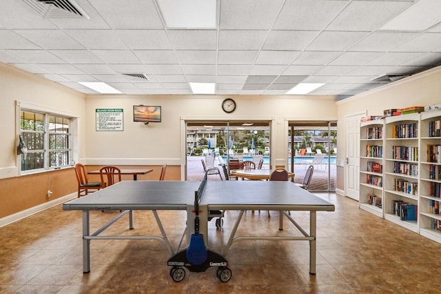 recreation room with tile patterned floors, a wealth of natural light, and a drop ceiling