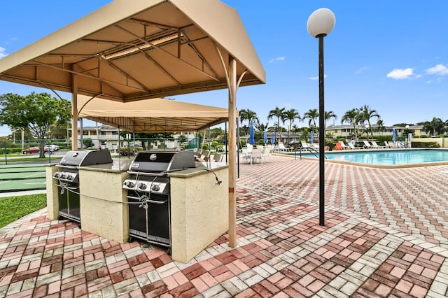 view of patio / terrace with a community pool and grilling area