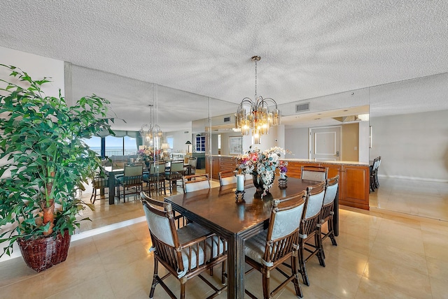 dining room featuring a textured ceiling, a chandelier, and light tile patterned floors