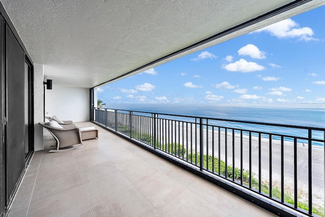 balcony with a beach view and a water view