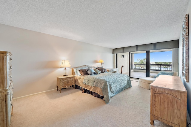 carpeted bedroom featuring a textured ceiling and access to exterior