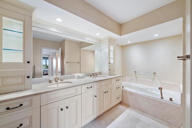 bathroom with tile patterned floors, a relaxing tiled tub, and dual vanity