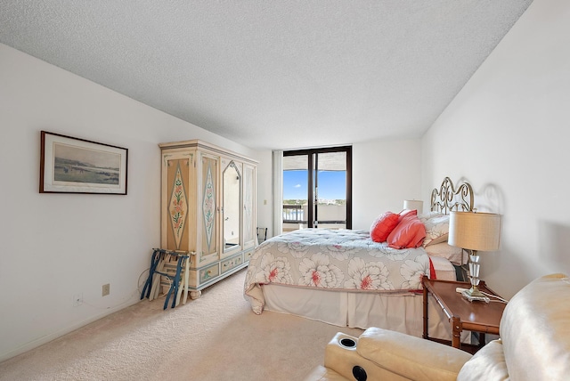 carpeted bedroom featuring a textured ceiling and access to exterior