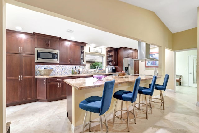 kitchen with light tile patterned floors, appliances with stainless steel finishes, lofted ceiling, island range hood, and a breakfast bar