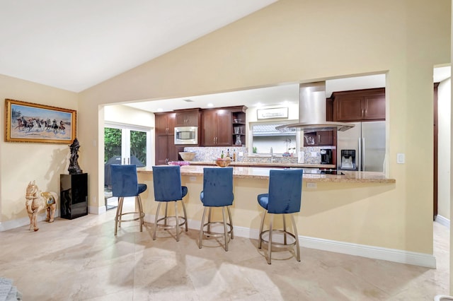 kitchen with appliances with stainless steel finishes, a kitchen bar, light tile patterned floors, and island range hood