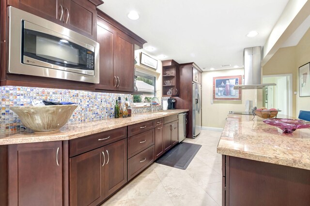 kitchen with light tile patterned floors, backsplash, appliances with stainless steel finishes, island exhaust hood, and sink