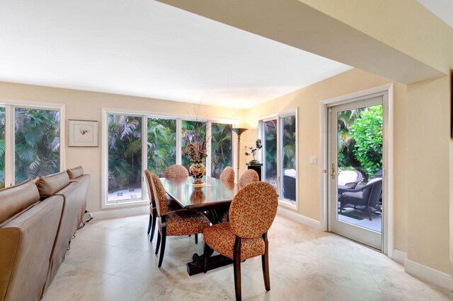 tiled dining space featuring plenty of natural light