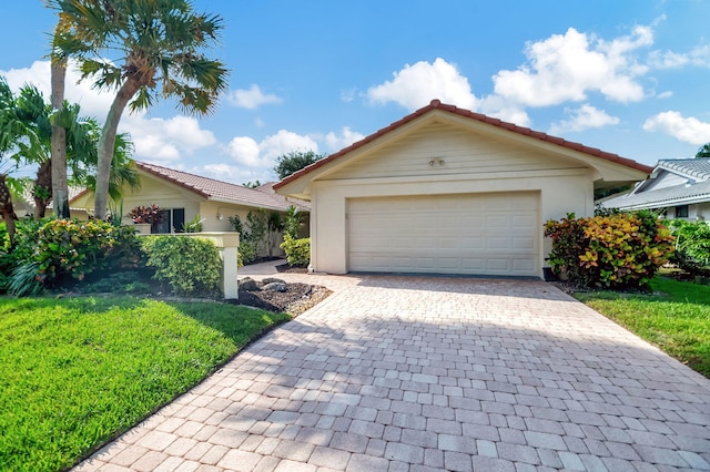 single story home featuring a garage and a front yard