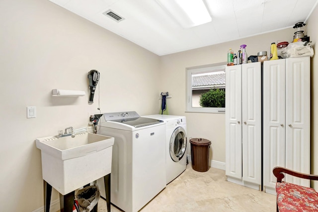 laundry area featuring cabinets, washer and clothes dryer, sink, and light tile patterned floors