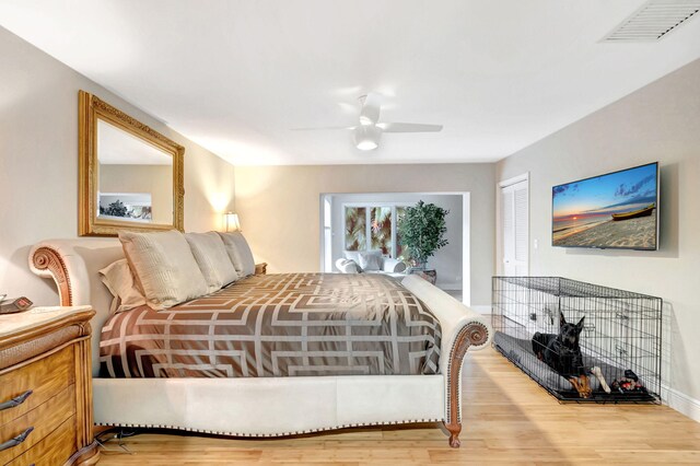 bedroom with light wood-type flooring, ceiling fan, and a closet