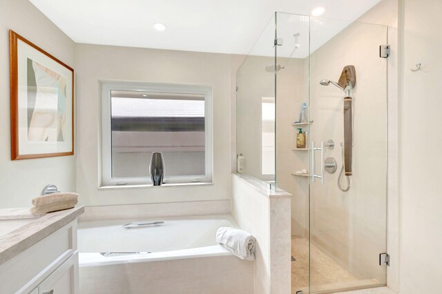 bathroom with vanity and independent shower and bath