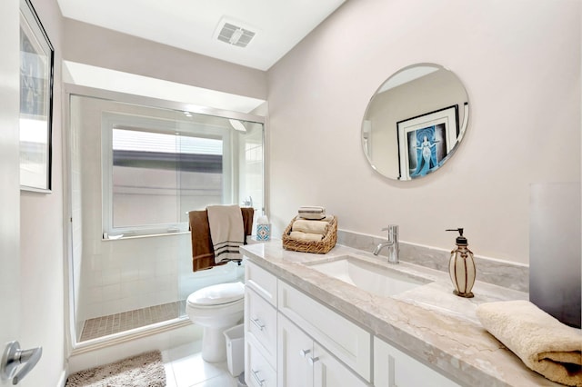 bathroom with a shower with door, vanity, toilet, and tile patterned flooring