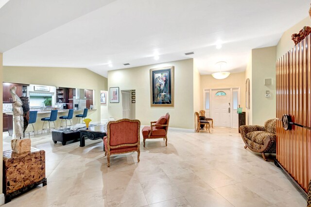 tiled living room featuring vaulted ceiling