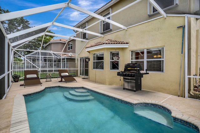 view of swimming pool with glass enclosure, a grill, and a patio