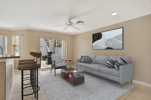 tiled living room with crown molding, ceiling fan, and a textured ceiling