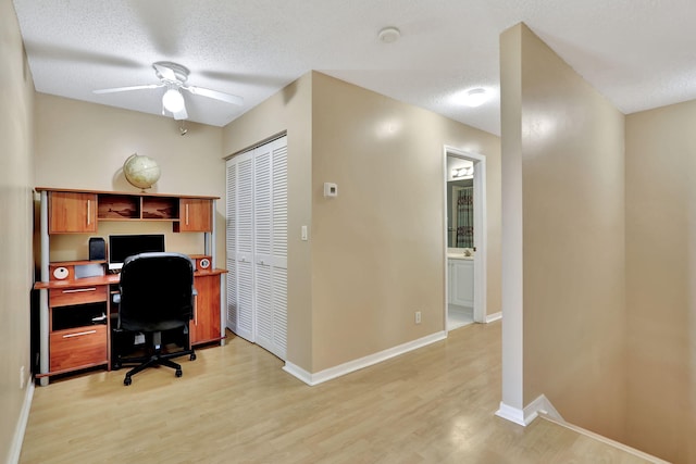 office area featuring a textured ceiling, light wood-type flooring, and ceiling fan