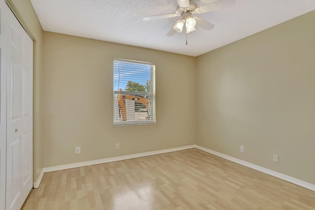 unfurnished bedroom featuring ceiling fan, a closet, light hardwood / wood-style floors, and a textured ceiling