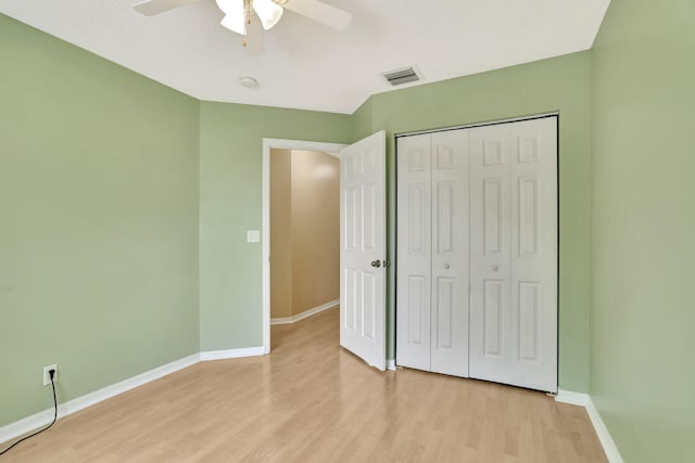 unfurnished bedroom featuring ceiling fan, light wood-type flooring, and a closet